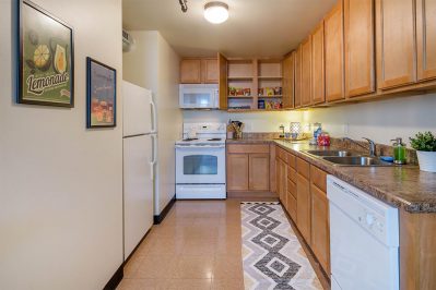 Image Of A Kitchen With Wooden Cabinets, A Stove, An Oven, A Sink, And A Fridge