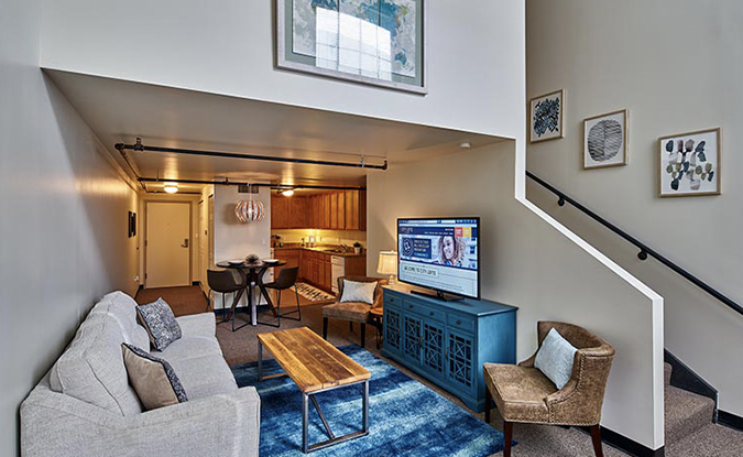 Image Of A Living Room, Kitchen, Front Door, And Stairwell At City Lofts on Laclede